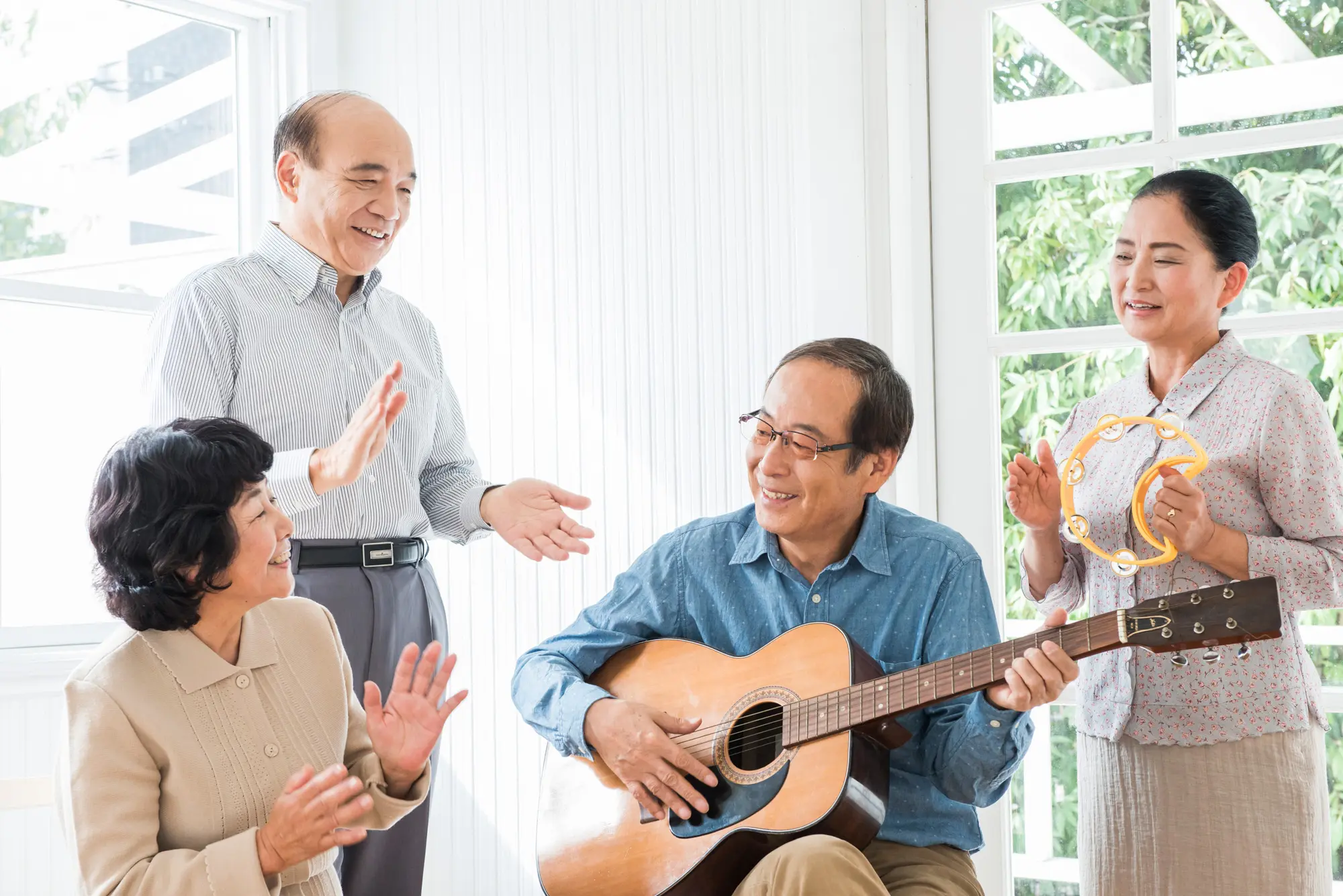 ギターを弾く男性と手拍子する人たち